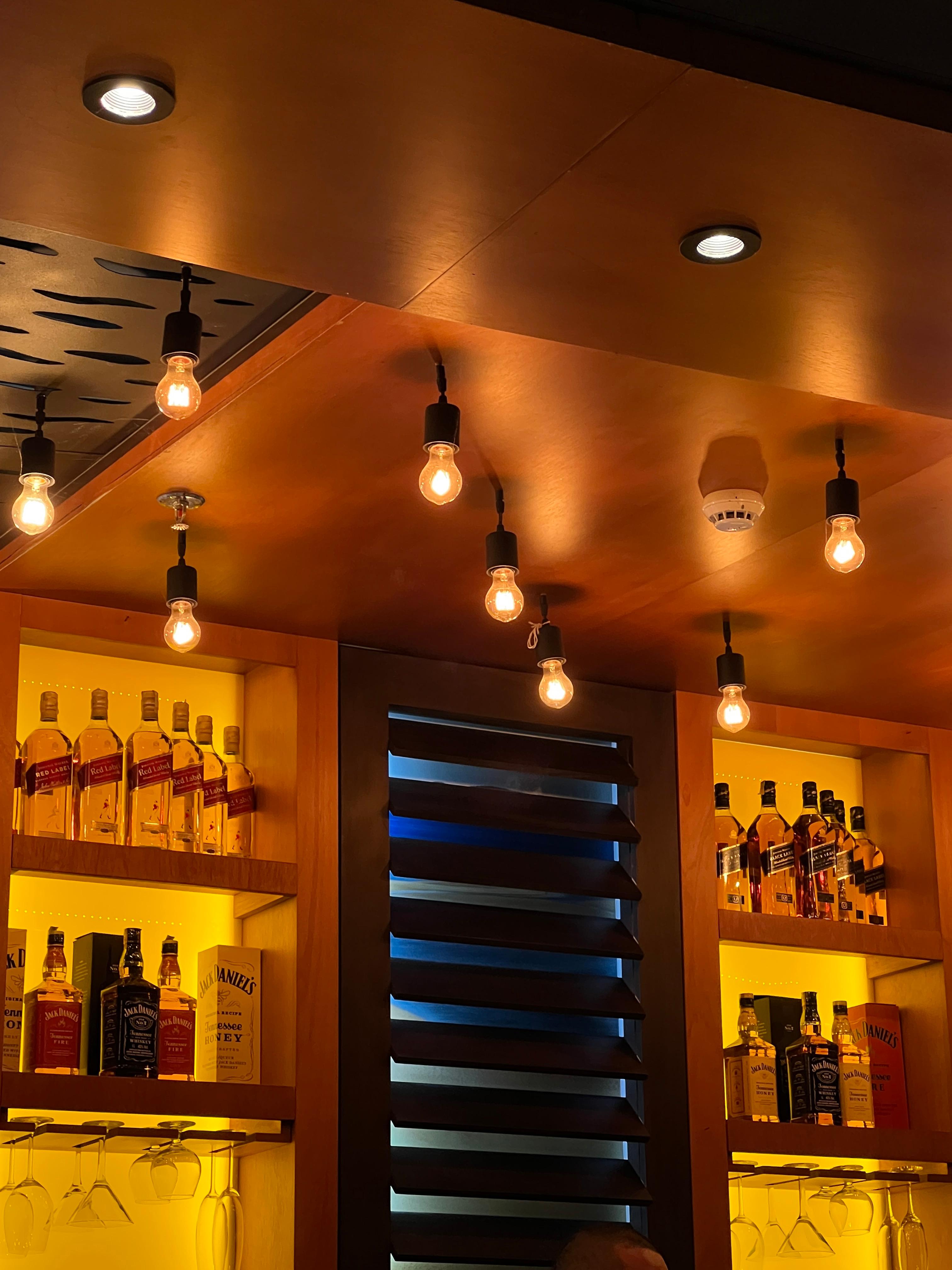 A shelf with lights and bottles of liquor